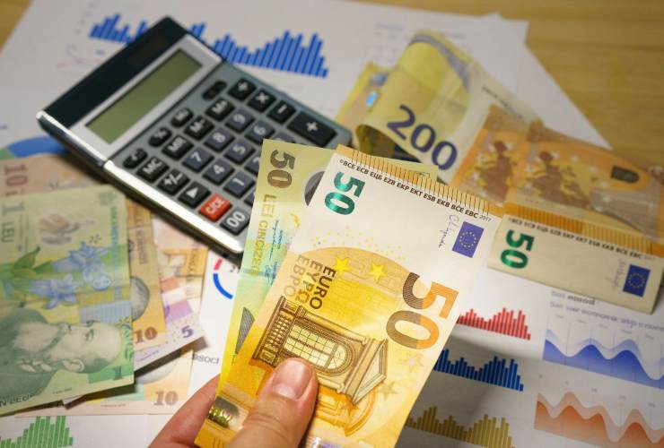 calcolatrice e banconote con grafici di dati pensionistici