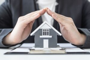 mani che proteggono una casa in miniatura
