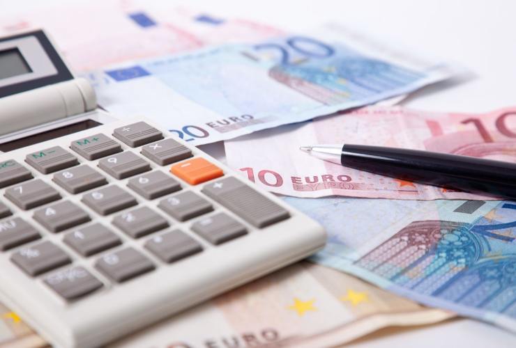 calcolatrice, banconote e penna