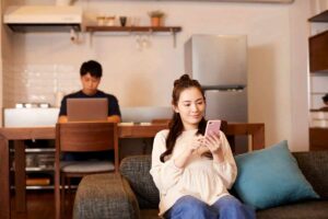 donna al cellulare e uomo al pc