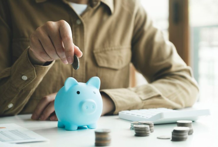 persona che mette soldi in un salvadanaio