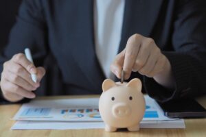 persona che mette una moneta nel salvadanaio
