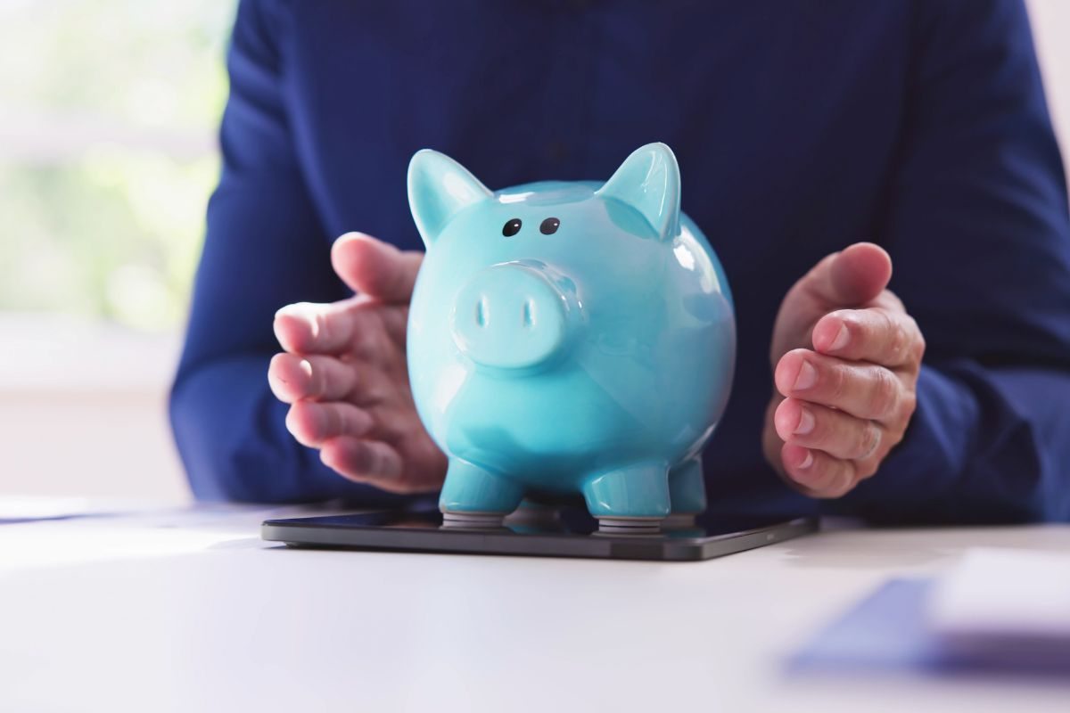 persona che tiene fra le mani un salvadanaio